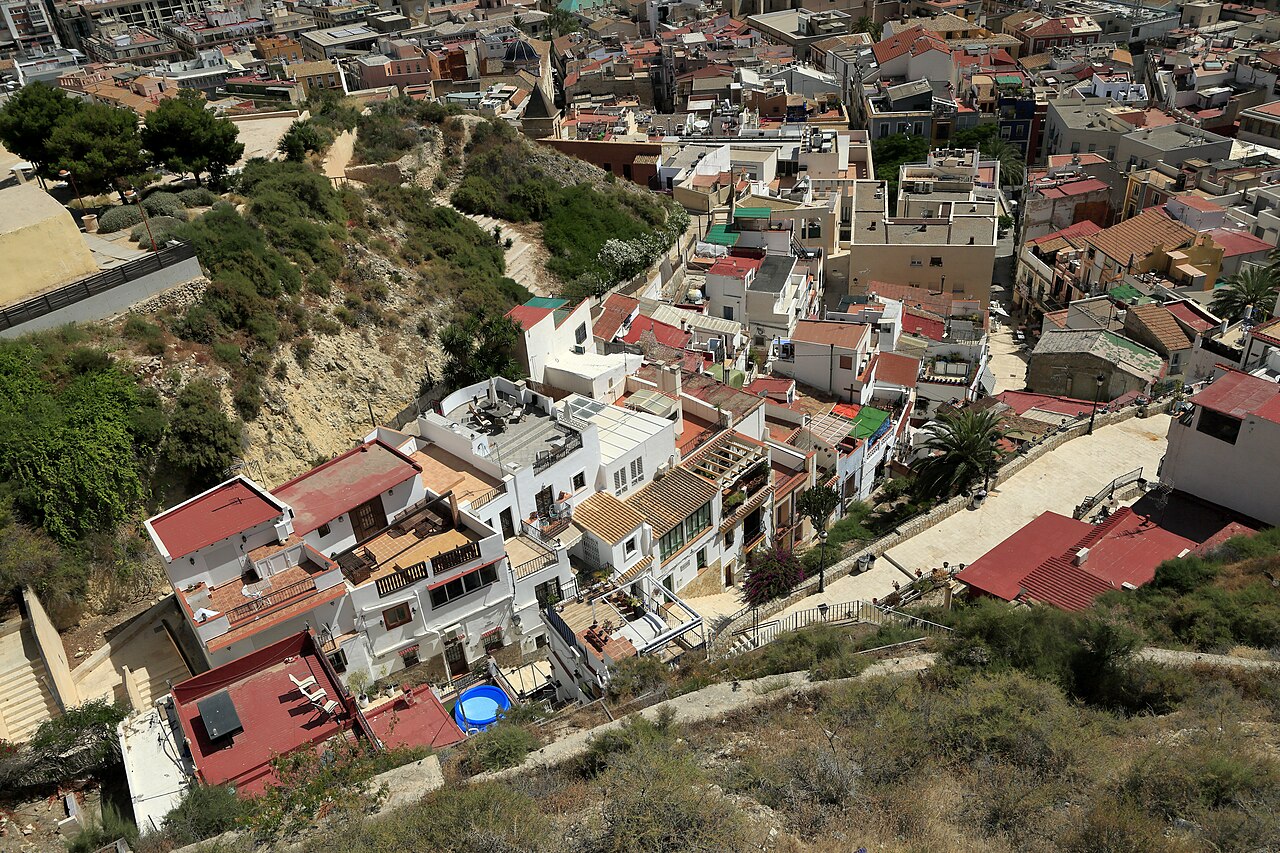The Santa Cruz barrio from above, tiled roofs stacked up the hillside below the castle